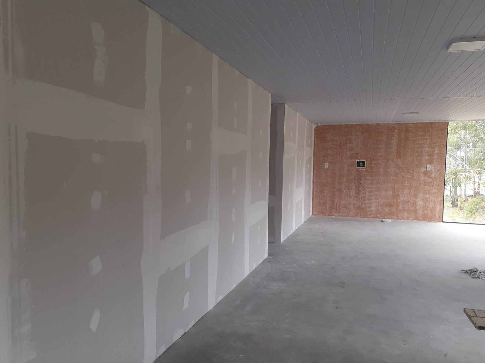 Paredes de gesso recebendo acabamento de massa corrida.