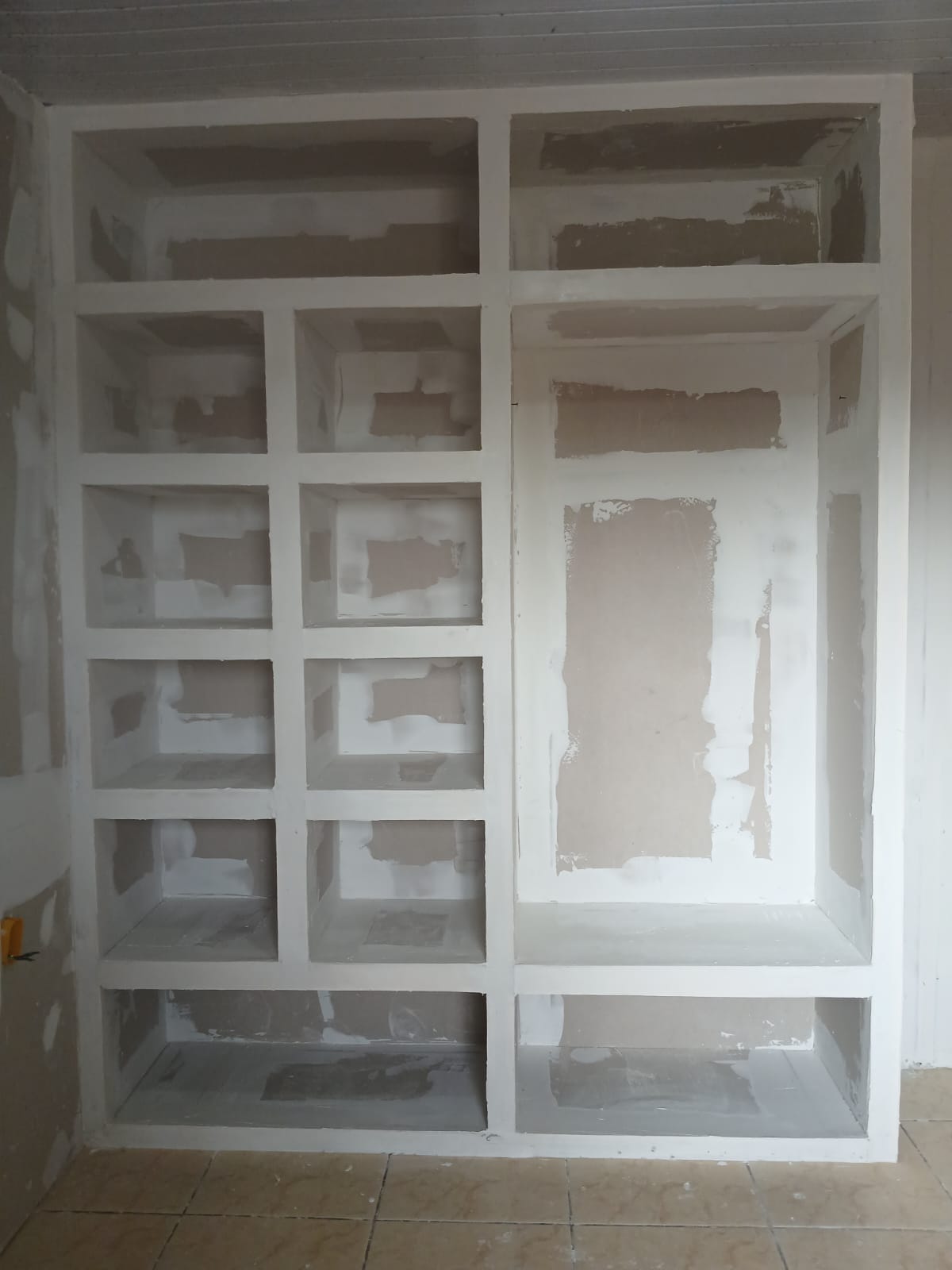 Estante e nichos de drywall sob medida em fase de acabamento.